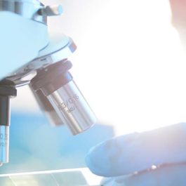 man looking at microscope in laboratory