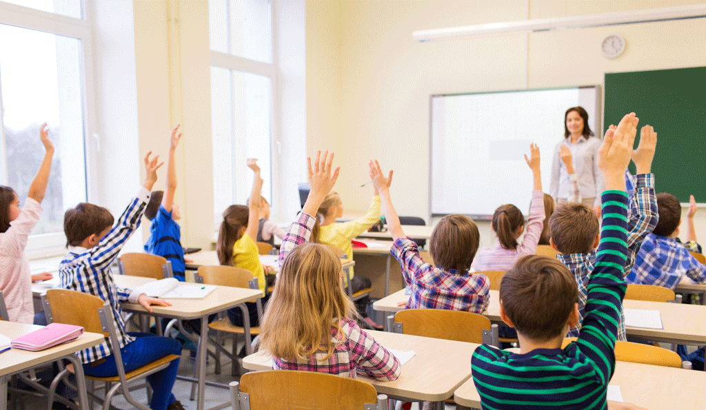 Students raising hand in classroom