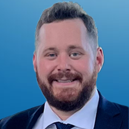 A photo of Greg Mylen with a blue backdrop